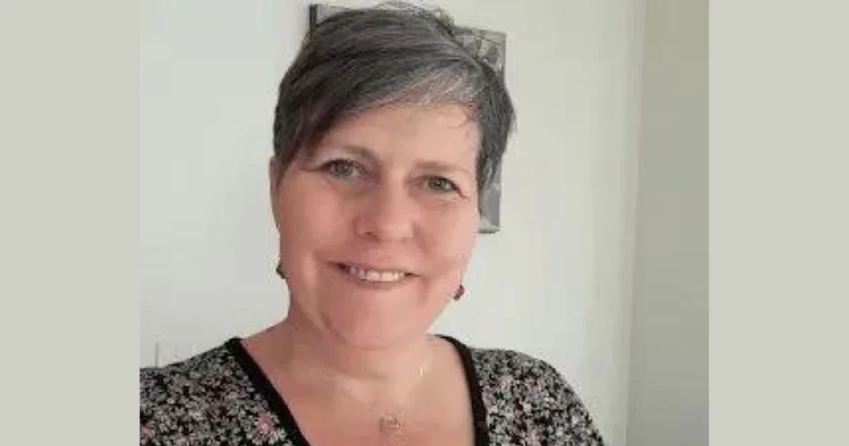 A woman with short grey hair smiling at the camera.