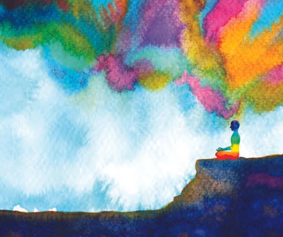 A silhouette of a person sitting in a meditative pose on a cliff, with colorful watercolor clouds rising above them.