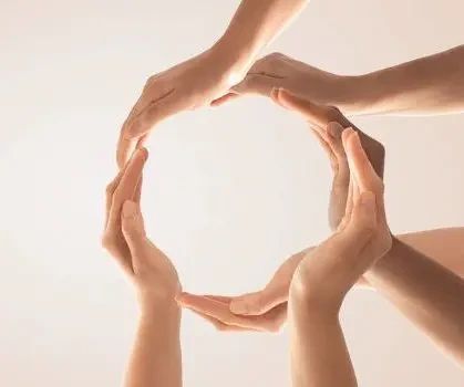 Multiple hands joined together in a circle.