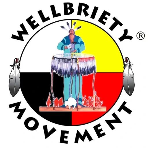 Logo for the Wellbriety Movement featuring an Indigenous person playing a large drum in front of a four-colored circle, framed by two feathers.