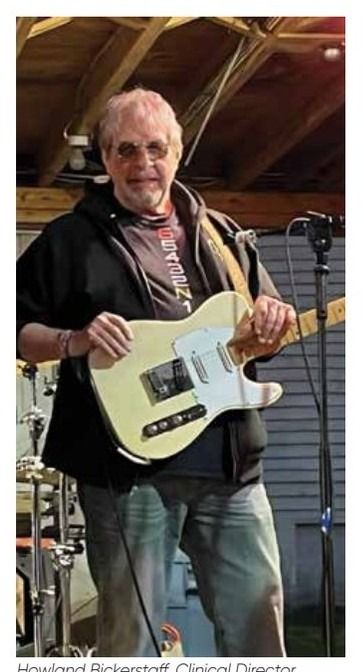 Howland Bickerstaff, Clinical Director, playing an electric guitar.