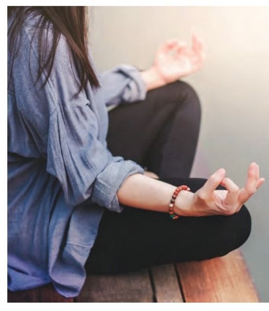 A person sitting in a lotus position with their hands in a mudra gesture.