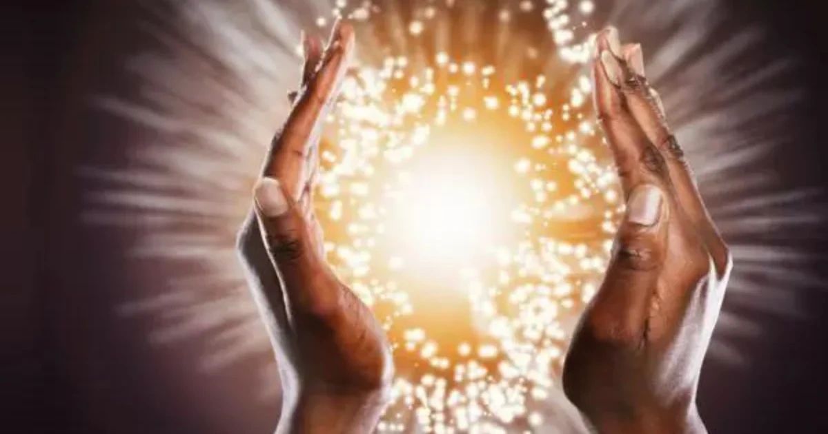 Two hands cupped around a glowing, sparkling light.